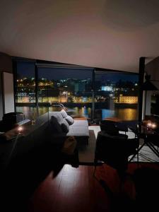 a living room with a view of a city at night at MY DOURO VIEW Stylish Gem River Front in Vila Nova de Gaia