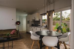 een keuken en eetkamer met een tafel en stoelen bij Panorama lodge with wellness and hottub 2 p. in Rijssen