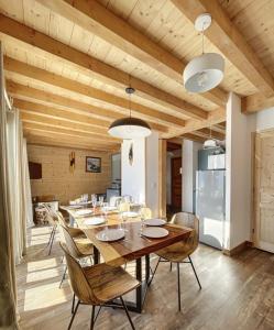 a dining room with a wooden ceiling and a table and chairs at Chalet Le Mauntenrojji - skis aux pieds in La Toussuire