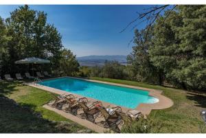 una piscina con sillas en un patio en Villa Linchiano, en Gambassi Terme