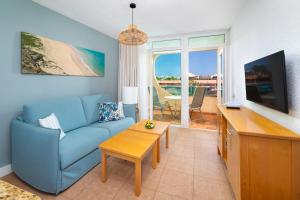sala de estar con sofá azul y mesa en MUR Apartamentos Buenos Aires Gran Canaria, en Playa del Inglés