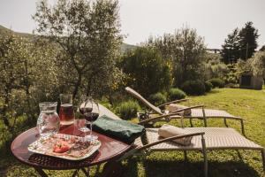La Veronica Exclusive Chianti Resort في غريفي ان شنتي: طاولة مع طبق من الطعام وكؤوس من النبيذ