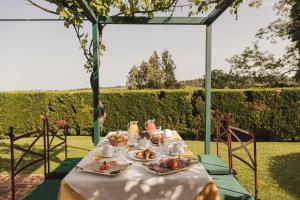 a table with a white table cloth and food on it at La Veronica Exclusive Chianti Resort in Greve in Chianti
