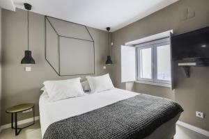 リスボンにあるMY LX FLAT Castle Alfama Studioのベッドルーム1室(白いシーツ付きのベッド1台、窓付)