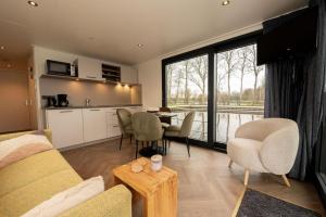 a living room with a couch and a table with chairs at Houseboat - Paviljoenwei 4 Sneek Offingawier in Offingawier