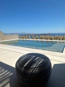 una ruota seduta a terra accanto a una piscina di Syros Soul Private Pool Suites a Ermoupoli