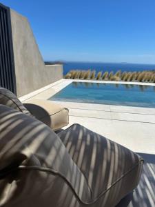 a couch sitting next to a swimming pool at Syros Soul Private Pool Suites in Ermoupoli