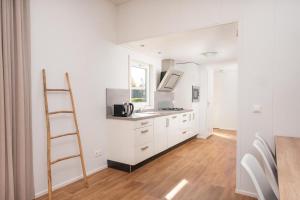 a kitchen with white cabinets and a ladder at Bungalette 6 people exclusive in Zuna +16 photos