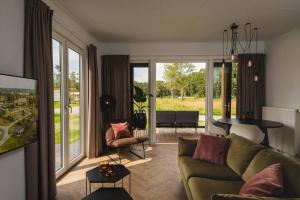 een woonkamer met een bank en een tafel bij Panorama lodge with jacuzzi 2 p. in Rijssen