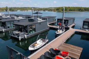 two boats are docked at a dock on a lake at Houseboat Marina Mookerplas 4-6 persons roof terrace in Plasmolen