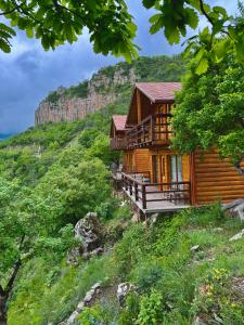 une cabane en rondins sur une colline avec une montagne dans l'établissement Harsnadzor Eco Resort, à Halidzor