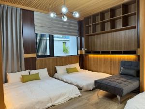 台南的住宿－Triple One Entire Home 慶東111私人招待所 包棟民宿，一间卧室设有两张床、一把椅子和一个窗户。