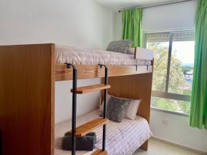 1 dormitorio con 2 literas y ventana en APARTAMENTO GEMINIS VISTA - WiFi - Parking, en El Puerto de Santa María