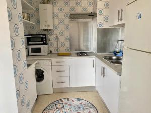 a small kitchen with a refrigerator and a sink at APARTAMENTO GEMINIS VISTA - WiFi - Parking in El Puerto de Santa María