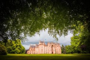 ein großes Schloss auf einem üppigen grünen Feld in der Unterkunft Buttermere Cottage in Banff