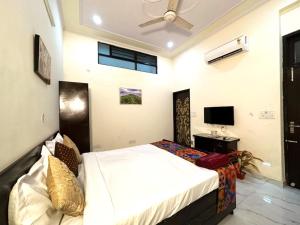 um quarto com uma cama e uma televisão em Jaipur Heritage Haveli em Jaipur