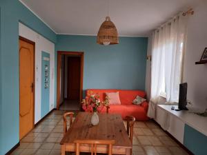 sala de estar con sofá rojo y mesa de madera en Al giardino Sant'Anna, en Mascali