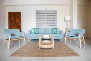 a living room with a blue couch and two chairs at MyHaus Apartments in Hyderabad