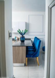 cocina con mesa y silla azul en Blue Waves Luxury Apartment- Power Backup, en Johannesburgo