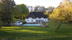 een groot wit huis met een zwembad in de tuin bij Romantique petite chaumière près de Guérande in Saint-Lyphard