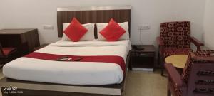una habitación de hotel con una cama grande con almohadas rojas en Mount Heera Hotel-Alandur en Chennai