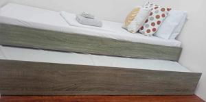 - un lit avec des draps et des oreillers blancs dans l'établissement La Vee s Home -Tiny Living, à Minglanilla