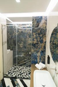 a bathroom with a shower with a toilet and towels at Hotel Cala Moresca in Bacoli