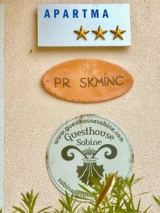 twee tekens aan de zijkant van een muur bij Guesthouse Sabine - pr` Skminc in Bohinjska Bela