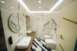 a bathroom with two toilets and a sink and a mirror at Hotel Cala Moresca in Bacoli