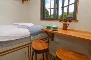 1 dormitorio con 1 cama y 1 mesa con 2 sillas en Lowena, en Penzance