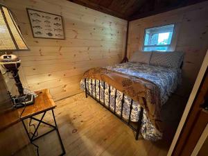 Bryant Pond的住宿－Toms Cabin On Lake Christopher，小木屋内一间卧室,配有一张床
