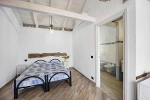 a white room with a table and a bathroom at Studio Nido in Pompeiana