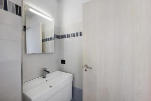 a white bathroom with a sink and a mirror at Studio Nido in Pompeiana +12 photos