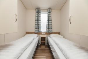 a room with three beds in it with a window at Mobile home by the Regge I 4 people in Zuna