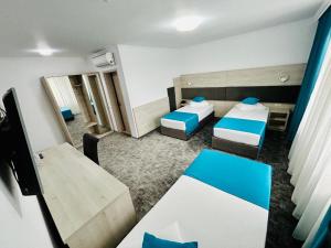 mały pokój z 2 łóżkami i stołem w obiekcie Hotel Bliss w mieście Roman