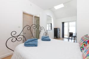 a white bedroom with a bed with towels on it at 23A Wharton Road in Oxford