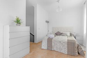 a white bedroom with a bed and a dresser at Casa Genoves in Garachico