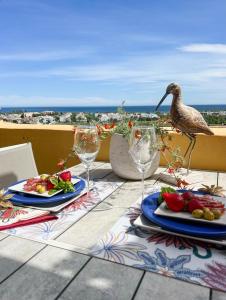a bird standing on a table with food and wine glasses at 62 - Penthouse in Los Almendros with fantastic vie in Marbella