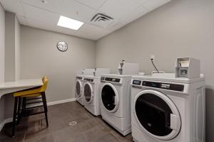 プエブロにあるTownePlace Suites by Marriott Pueblo Downtownの洗濯機3台とカウンター付きのランドリールーム