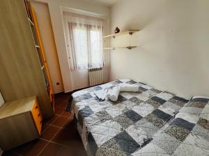 a bedroom with a bed with a checkered blanket at Appartamento Girasole in Girasole