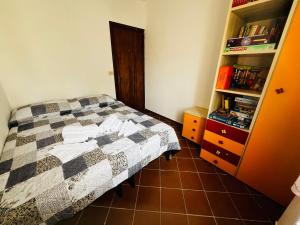 1 dormitorio con cama y estante para libros en Appartamento Girasole, en Girasole