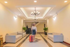 a woman standing in a lobby with her luggage at Saigon-Ba Be Resort in Ba Be