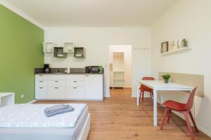 a room with a bed and a table and a kitchen at Gästehaus Goldberg in Goldberg