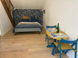 um quarto com uma cama e uma mesa com uma garrafa de vinho em Chambre double avec salle de bains privée em Quintin