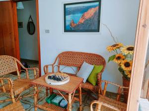 Habitación con sillas de mimbre y mesa con tablero de ajedrez. en Casa Panarea - Villetta indipendente sul mare, en Marina di Modica