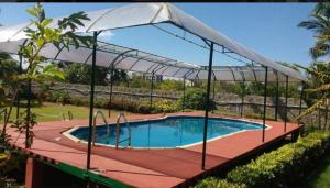 una piscina con una sombrilla encima en Royal Experiences Chettinad Sea Side Villa, Kanathur ECR Chennai, en Chennai