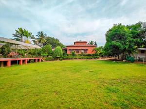 a large grassy yard with a building in the background at Royal Experiences Chettinad Sea Side Villa, Kanathur ECR Chennai in Chennai
