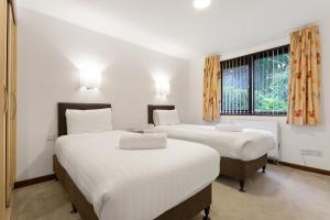 - une chambre avec 2 lits et une fenêtre dans l'établissement Hapimag Burnside Park Apartments, à Bowness-on-Windermere
