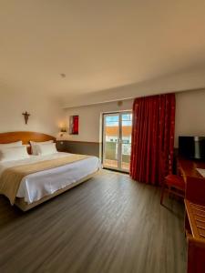 ein Schlafzimmer mit einem großen Bett und einem roten Vorhang in der Unterkunft Hotel Santo Amaro - SA Hotels in Fátima