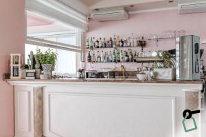 un bar in una stanza con parete rosa di HOTIDAY Hotel Jesolo Spiaggia a Lido di Jesolo